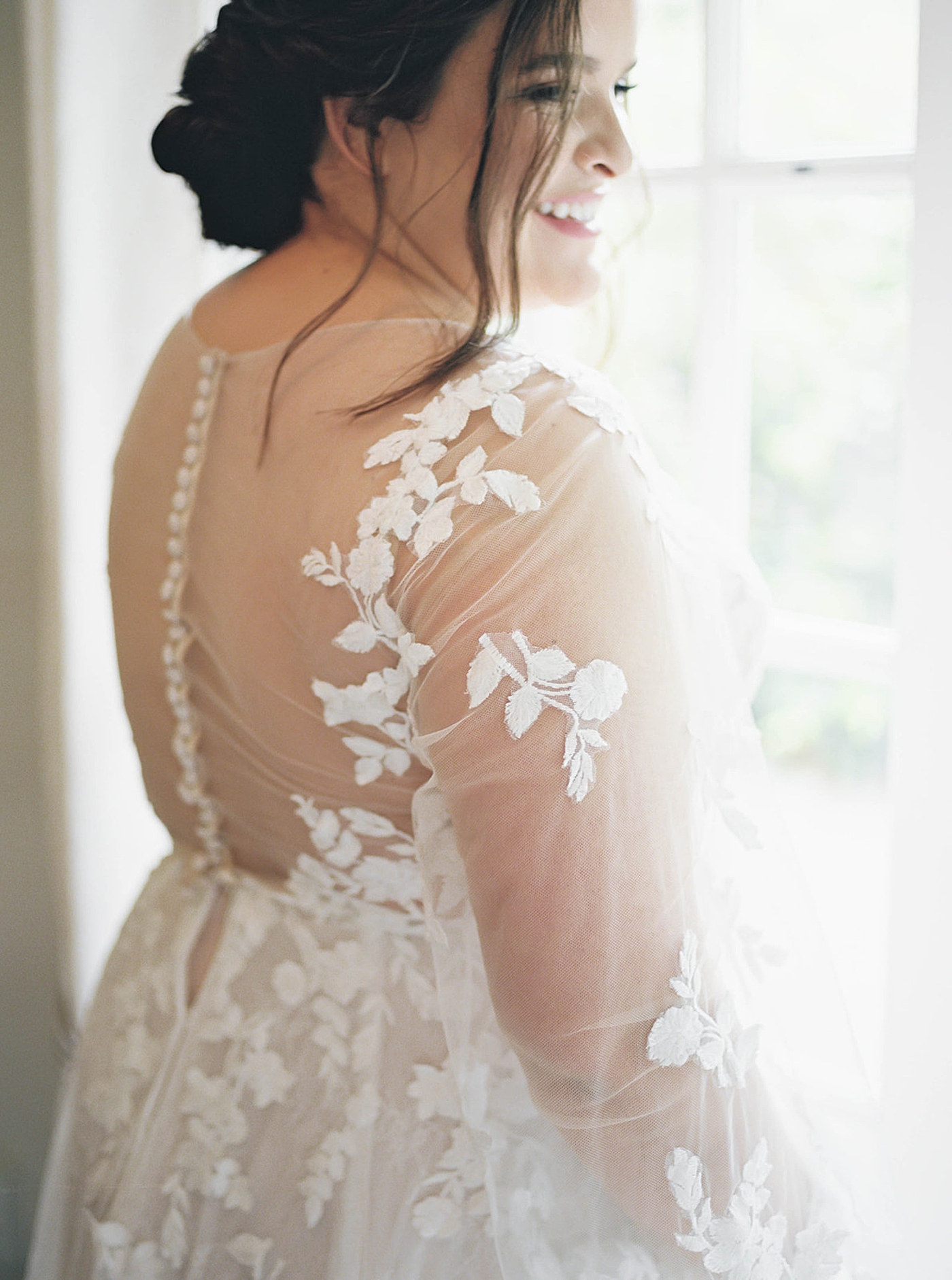 Bride standing near a window in a lace gown | Carters Event Co