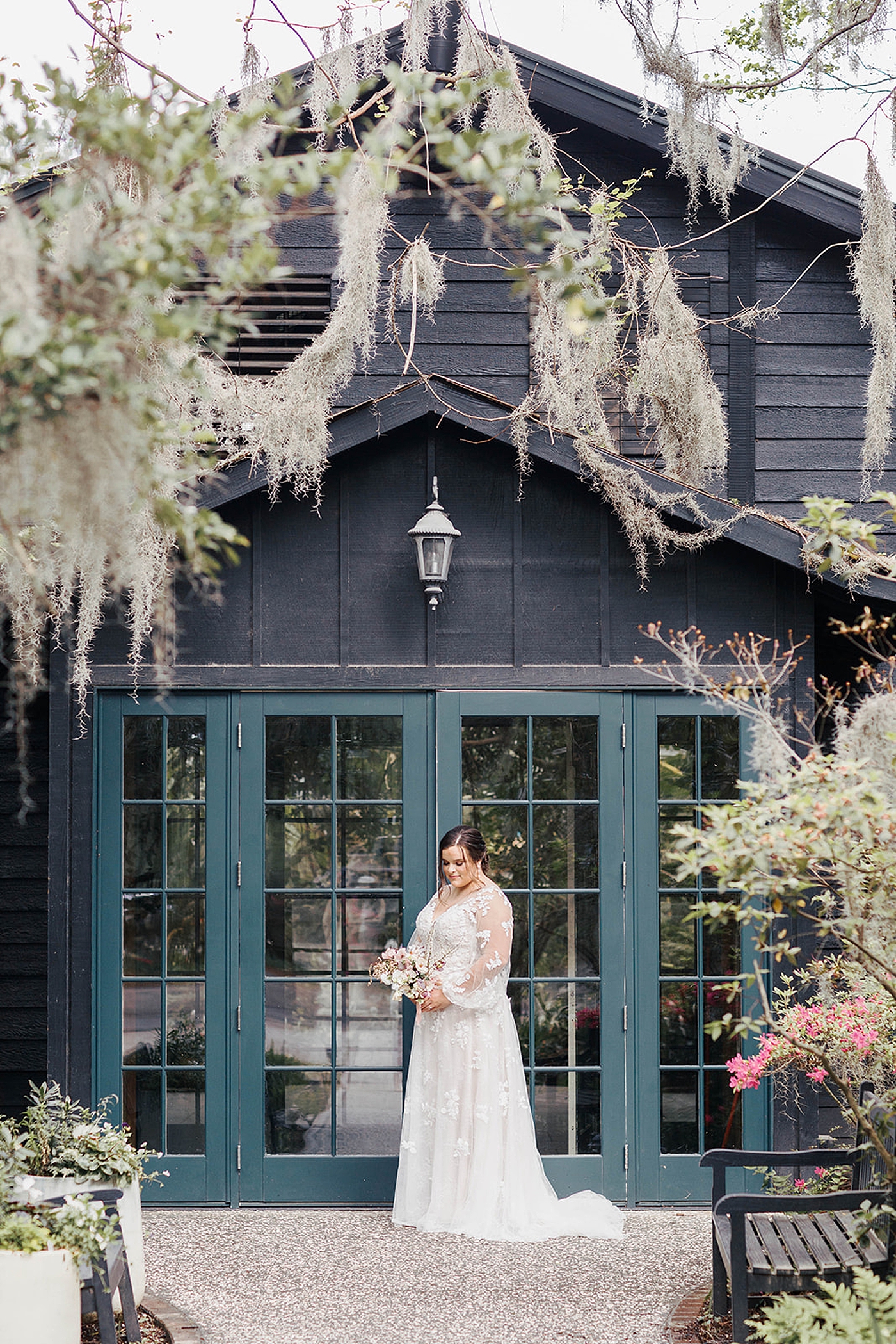 Bride in a lace gown in front of a greenhouse | Carters Event Co