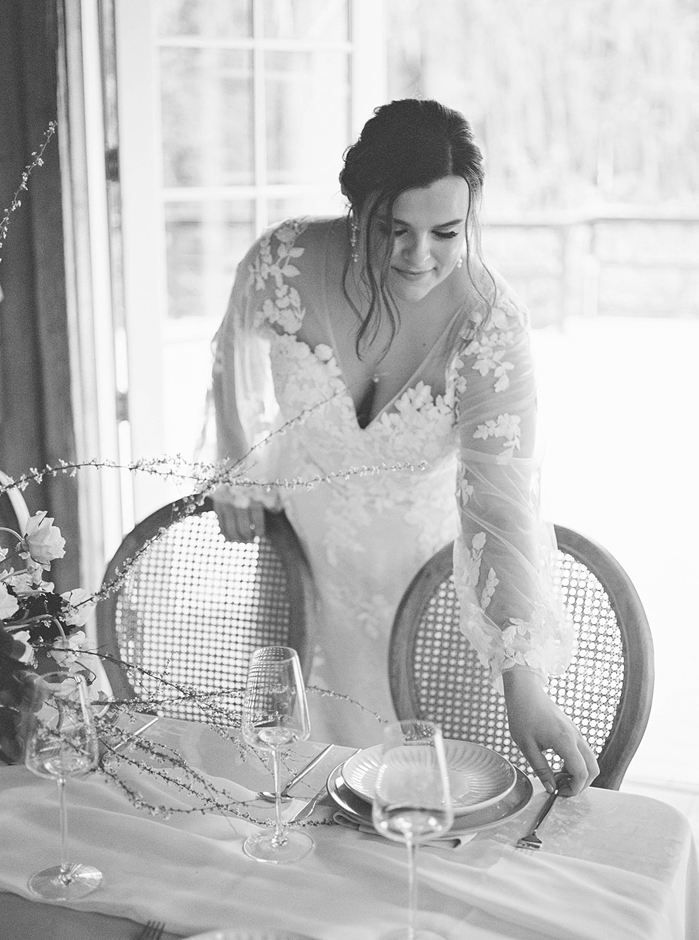 Black and white image of bride adjusting flatware | Carters Event Co