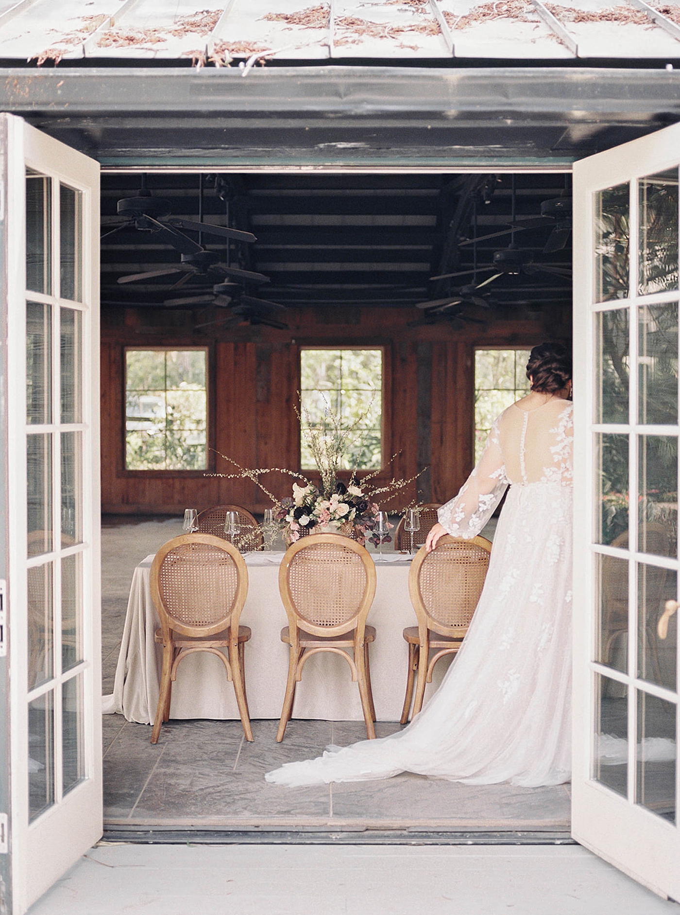 Bride walking by a table through a doorway | Romantic French Countryside Editorial by Carters Event Co
