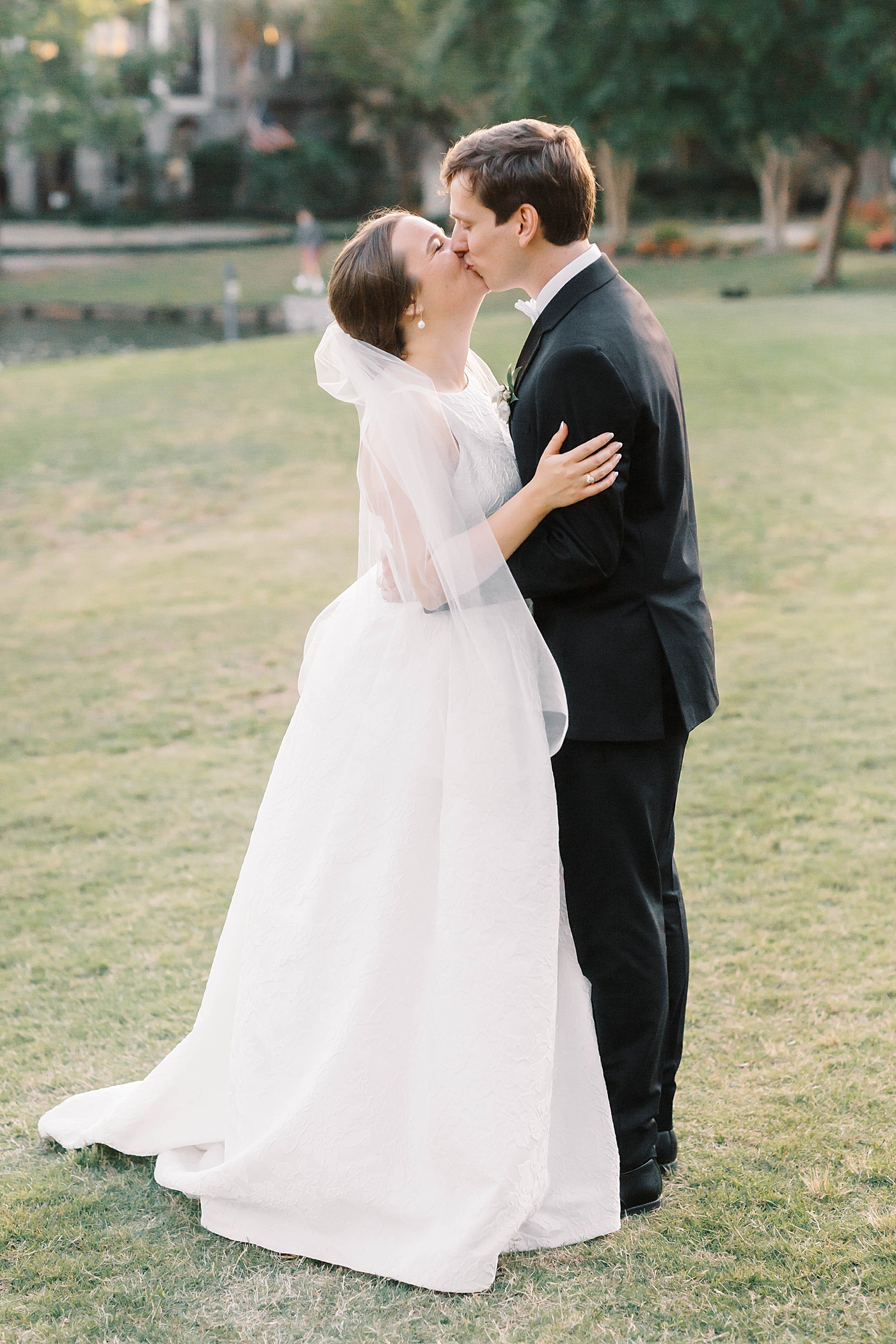 Bride and groom kissing near a pond | Carters Event Co