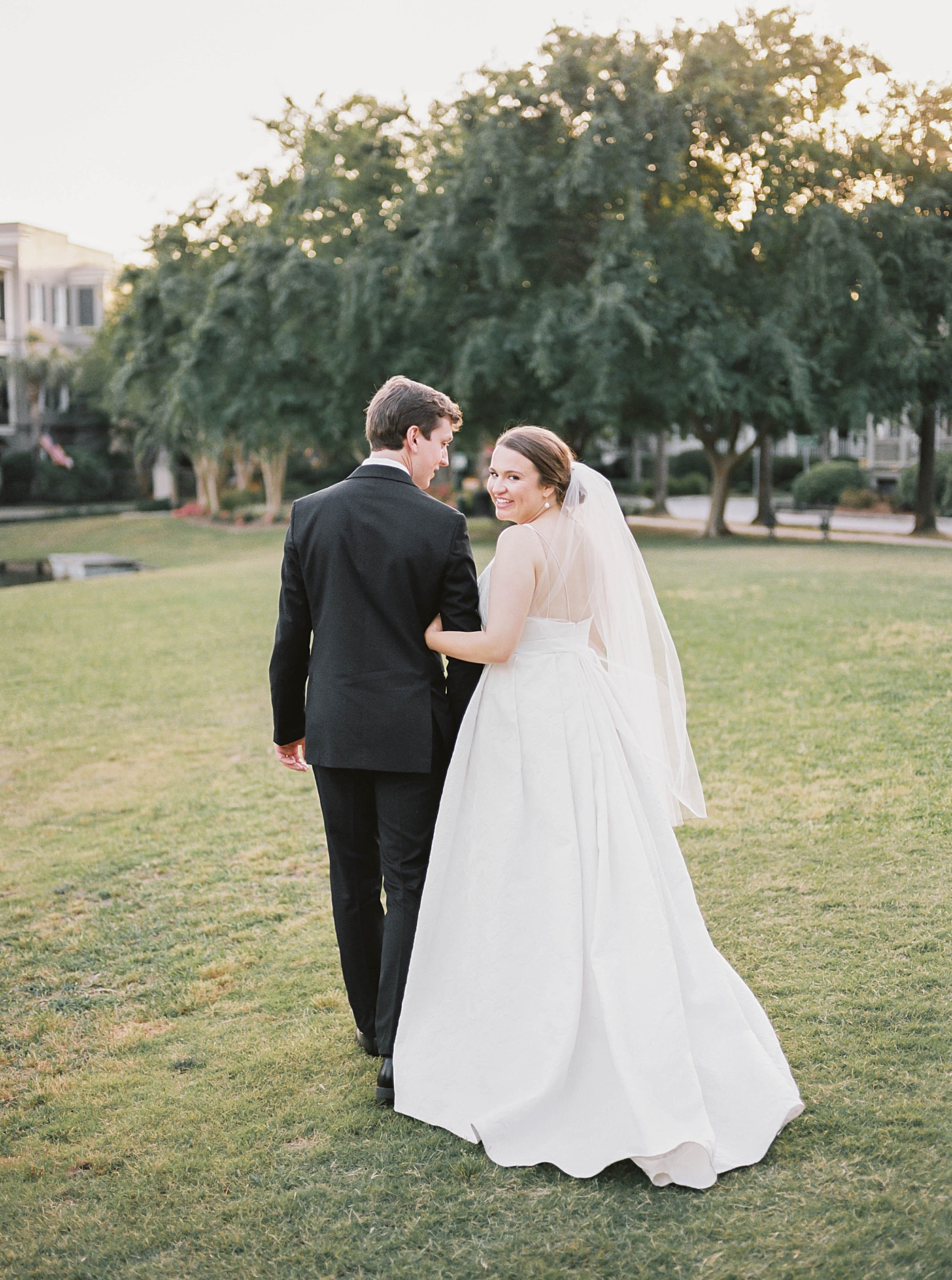 Bride looking over her shoulder walking with groom during their Intimate spring wedding | Carters Event Co