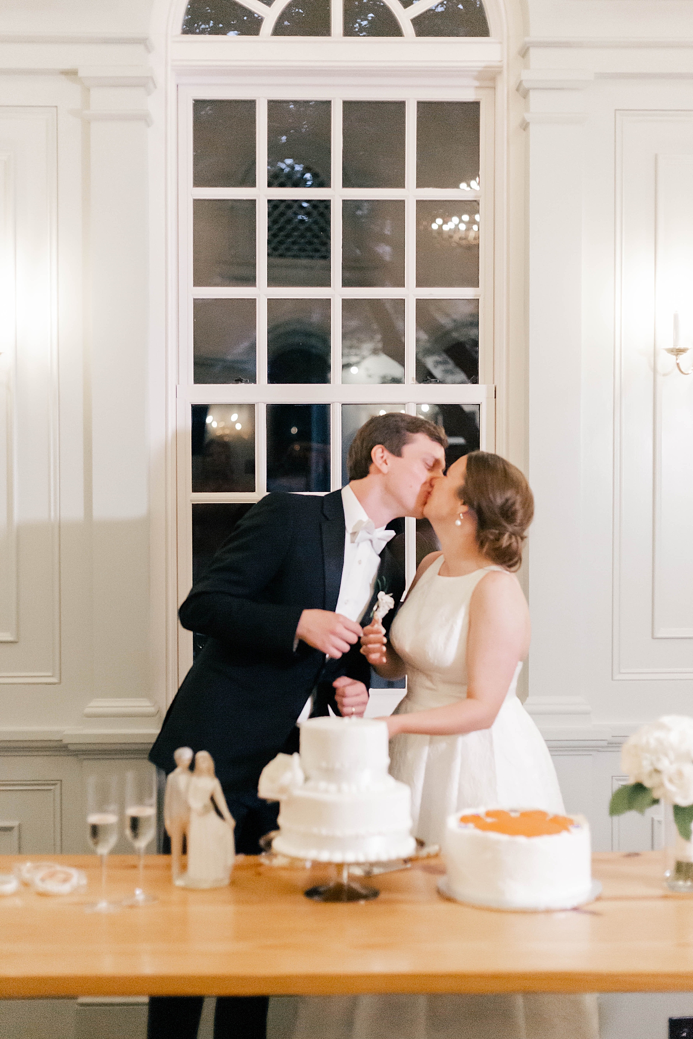 Bride and groom kissing while cutting their wedding cake | Carters Event Co