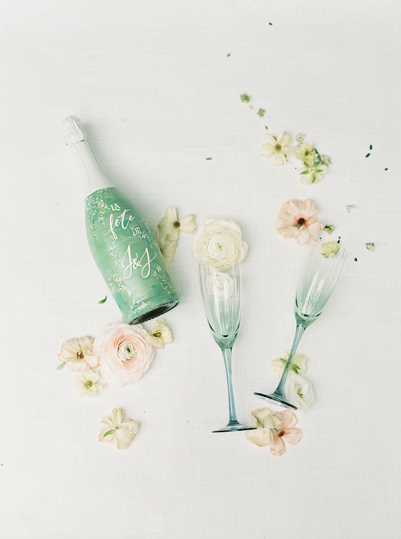 Painted champagne bottle with pale blue champagne flutes with florals | Carters Event Co