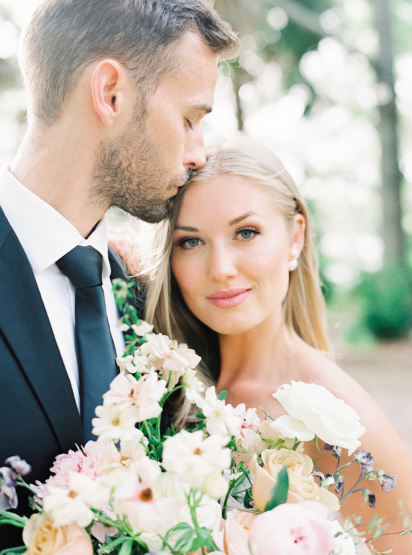 Detail of bride holding flowers kissed by groom | Carters Event Co